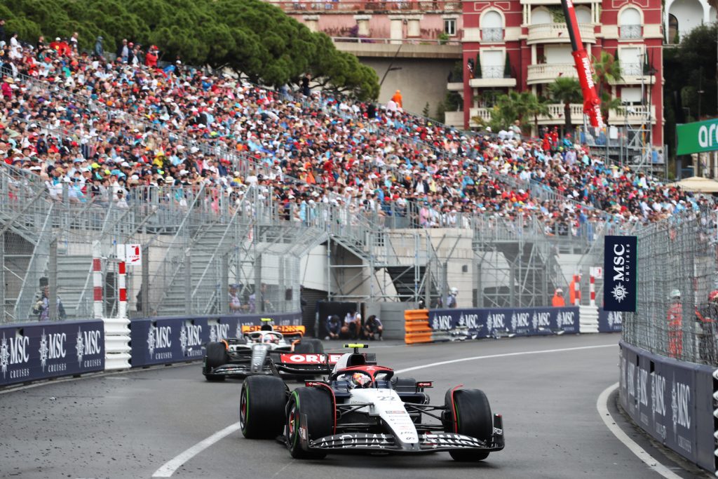 F1 race cars driving on the track with crowds in the background
